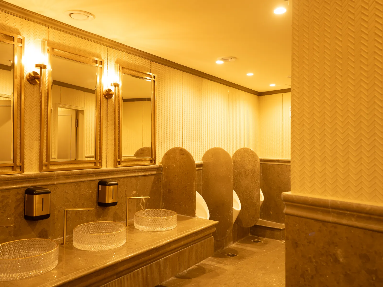 Restroom with brass-framed mirrors and glass basins — Chalukya Samrat